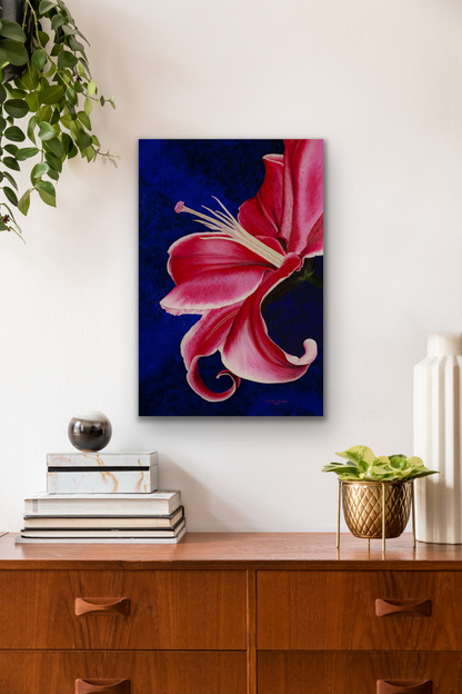 The work of art has bright pinks and reds in the petals and deep blue background.